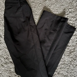 Svarta kostymbyxor från Bik Bok - Säljer ett par klassiska svarta kostymbyxor från Bik Bok. Byxorna har raka ben, diskreta fickor och stängs med dragkedja och knapp. Perfekta för en stilren look och passar till många olika outfits💕