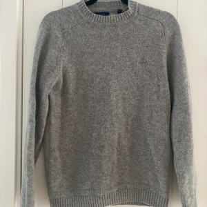 Ny grå stickad tröja i 100% ull från Gant i strl S - Ny, aldrig använd.  Mått Över axeln: ca 42 cm Längd från axeln och ner: ca 66 cm  100% ull  Kommer från ett djur och rökfritt hem.