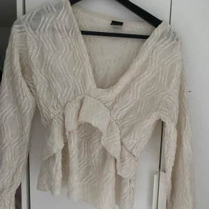 Beige blus med volang  - Fin blus från Gina 