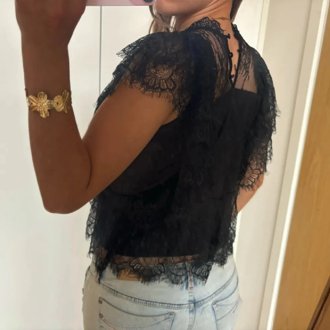 Svart spetsblus med volangdetaljer - 1