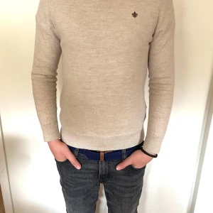 Beige merinoulltröja från Morris - Säljer en stilren beige tröja från Morris i mjuk merinoull. Tröjan har rund halsringning och en liten broderad logga på bröstet. Perfekt för dig som gillar klassisk och enkel stil. Stl L barn men sitter som xss. Pris kan diskuteras vid snabb affär💯