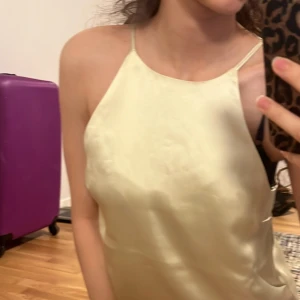 Ljusgul satinlinne med smala axelband - Säljer en ljusgul satinlinne med tunna axelband och rak halsringning. Prislappen är fortfarande på, så hör av dig ifall du är intresserad  🫶 den har aldrig använts, och är helt ny