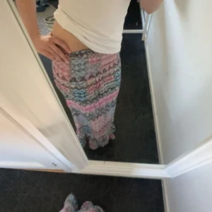 Färgglad långklänning/långkjol - Säljer en långklänning från Topo med färgglatt mönster i rosa, blått, lila och vitt. Klänningen har volang nertill och ett bohemiskt, mönstrat tyg som ger en lekfull känsla. Perfekt för dig som gillar färg och mönster! Denna är köpt i en marknad utomlands 💕