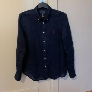 Mörkblå skjorta från Polo Ralph Lauren - Tjena säljer min Ralph lauren skjorta eftersom den satt lite stor på mig. Skjortan har aldrig använts. Skick 10/10. Priset går att diskutera.