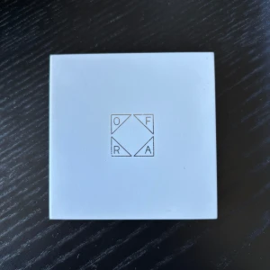 OFRA Highlighter Rodeo Drive - Säljer en OFRA highlighter i nyansen Rodeo Drive. Kommer i en vit fyrkantig dosa med spegel. Highlightern har en guldig, skimrande finish och är pressad i ett solstråle-mönster. Perfekt för att ge glow till ansiktet. Sparsamt använd!