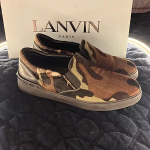 Valentino slip-on sneakers med camouflage - Säljer ett par Valentino slip-on sneakers.Skorna  är i super fint skick och är väldigt svåra att få tag i. jag tar jättegärna emot byten som vanligt men går självklart att köpa. Skorna är i storlek 41 men passar lite större. Har ni några frågor är det bara att skicka iväg meddelande så svarar jag oftast väldigt snabbt med det sagt. Tack för er uppmärksamhet. Med vänliga hälsningar Oscar
