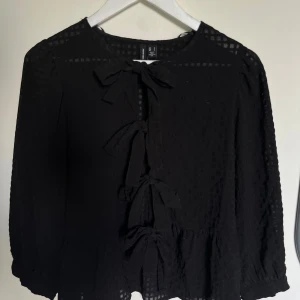 Svart blus med rosetter - Säljer denna fina toppen med rosetter från Veromoda. Använd fåtal gånger. Hör av dig vid frågor🫶🏻