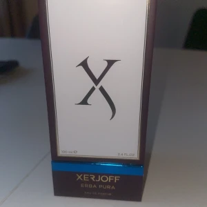 Xerjoff Erba Pura Eau de Parfum 100ml - Lyxig parfym från Xerjoff, Erba Pura, i en elegant blå flaska med sammetsliknande yta och guldfärgat lock. Kommer i exklusiv förpackning med guld- och blå detaljer. Flaskan rymmer 100 ml Eau de Parfum. OBS KVITTO FINNS