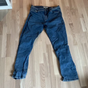 Blå jeans från Stock & Hank - Säljer ett par klassiska blå jeans från Stock & Hank. Jeansen har fem fickor, gylf med knapp och dragkedja samt raka ben. Perfekta till vardags för en avslappnad stil.