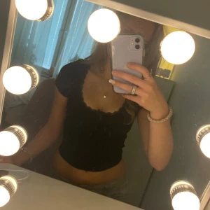 Svart gullig topp med spets frå H&M - Säljer en svart topp med spets och en liten rosett💘