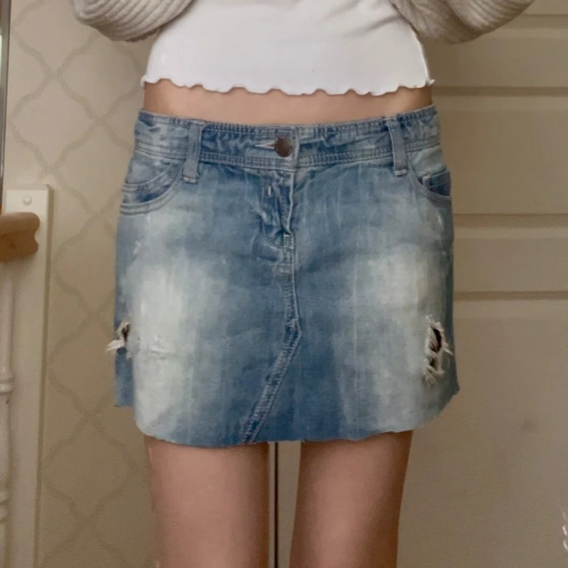 Blå jeanskjol med slitningar