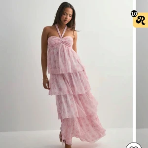 Ljusrosa långklänning med blommigt mönster - Säljer denna klännig pga att den är för stor för mig. Perfekt att ha till balen eller på sommaren. Den är helt oanvänd. Nypris 699kr. Pris kan diskuteras💓