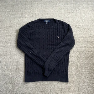 Kabelstickad Gant tröja - Tja! Säljer nu denna feta kabelstickade Gant tröja! Den har inga defekter alls! Den har en snygg och avslappnad marinblå färg med Gantloggan på! Den är varm så perfekt för dessa kyliga dagar! Skick: 10/10 Nypris: 999kr❌‼️ Mitt pris: 349kr✅ Skriv vid minsta fundering och pris kan diskuteras!🙌🤝