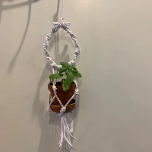 Makramé ampel / växthängare säljes.  - Upptäck hur du enkelt kan få en härlig känsla av  makramé-amplar för att hänga växter snyggt i hemmet.  Säljer en unik vit ampel  i makramé-stil. Ampeln  har en rund form och är handgjord med tjockt vitt bomulls snöre. Perfekt för dig som vill ha en cool inredningsdetalj med boho-vibe. Ampeln har en öppen topp och dekorativa knutar.