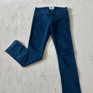 Tiger of Sweden jeans - Säljer ett par klassiska mörkblå jeansbyxor med normal passform. Byxorna har fem fickor, knapp och dragkedja framtill samt raka ben. Perfekta till vardags och enkla att matcha med olika stilar.