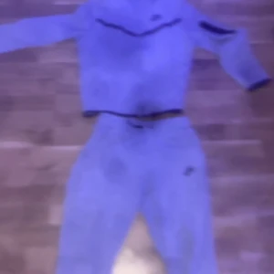 Nike tech fleece tracksuit  Grå - Säljer en grå croppad hoodie från Nike med lång ärm och klassisk huva. Perfekt för en avslappnad stil och passar bra till träning eller chill. Nike-logga på bröstet. Snygg och enkel design. Kamran e sönder därför ser de lite skumt ut, barn storlek 147-152 cm