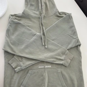 Ariana Grande Hoodie - Ariana Grande Positions Hoodie, köpt från hennes sida 2020. Använd och tvättad bara några fåtals gånger.  Hoodien är i bra skick, inga noppror eller flöckar däremot har trycket på ryggen lite sprickor från att den tvättas. Pris Kan diskuteras :)