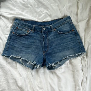 Blå jeansshorts med fransar från Levi's - Säljer ett par klassiska blå jeansshorts från levi’s. Perfekta för sommaren.