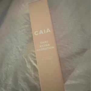 CAIA That Extra Hydration Moisturizing Setting Spray - Återfuktande setting spray från CAIA i en beige förpackning. Perfekt för att ge huden extra fukt och fixera sminket under dagen. Kommer i en smidig sprayflaska.helt ny oöppnad 