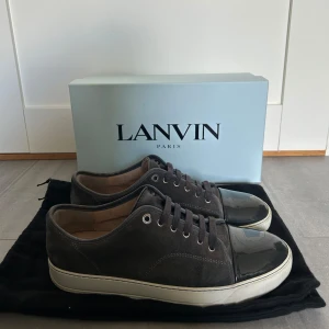 Lanvins - Säljer ett par grå sneakers från Lanvin med glansig tå! Skorna är i bra skick men har en del tecken på användning. Vid köp ingår box och dustbags! (Priset är förhandlingsbart)                                                              Vid frågor eller liknande är det bara att höra av sig!                    MVH Grischoutlet.