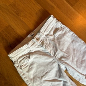 Vita low waist bootcut jeans från ONLY - Snygga vita jeans från ONLY med klassisk femficksdesign och bootcut-ben. Byxorna har normal midja och är tillverkade i mjuk bomullsblandning med lite stretch för extra komfort. Perfekta för dig som vill ha en fräsch och stilren look