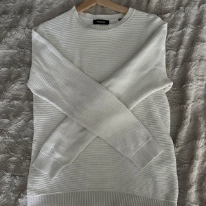 Vit ribbad tröja från Jack & Jones - Säljer en stilren vit tröja från Jack & Jones i storlek XS. Tröjan har ribbad struktur, rund halsringning och långa ärmar. Perfekt för dig som gillar en clean och enkel look. Materialet är mjukt och skönt, passar till många outfits.