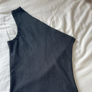 Svart top - En ärmad kortärmad top. Använd fåtal gånger. Den är i ett ribbat material. Svarar snabbt vid frågor❣️