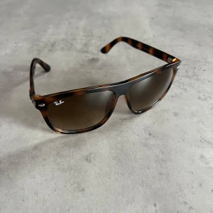 Ray-Ban Wayfarer - Snygga Ray-Ban Wayfarer RB4147 med brunmelerad båge och bruna tonade glas. Klassisk fyrkantig form och diskret Ray-Ban-logo på linsen. Bågarna är i plast och har en tidlös vibe som passar till allt. Perfekt nu inför sommaren och det soliga vädret.