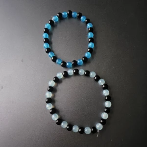 Två Armband I Blått o Svart - Två elastiska armband med runda pärlor i svart, blått.