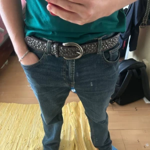 Nitbälte från liebeskind Berlin  - Nitbälte från liebeskind Berlin. Säljer ett brunt skärp i skinn med massor av runda nitar längs hela bandet. Spännet är i metall och har en snygg, lite vintage känsla. Perfekt accessoar för att ge outfiten lite extra edge och karaktär.