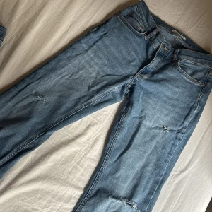 Ljusblå bootcut jeans med slitningar - Snygga ljusblå jeans från Perfect Jeans med bootcut passform och slitna detaljer på benen. Klassisk femficksmodell med normalhög midja och dragkedja. Perfekta för en avslappnad och trendig look.