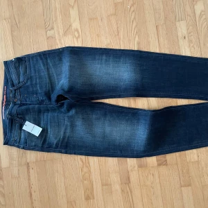 Mörkblå jeans JJI MIKE från Jack & Jones - Snygga mörkblå jeans från Jack & Jones, modell JJI MIKE JJCade. Klassisk femficksdesign, orangea sömmar och diskret tvättad look. Jeansen har normal passform och är perfekta för dig som gillar en stilren och enkel look. Kom med frågor om du undrar något.😃