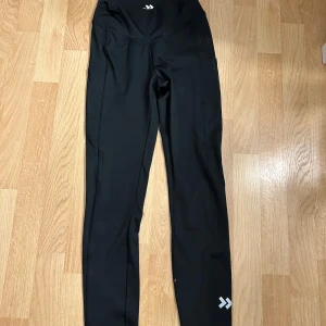 Tränings leggings från 157  - Svarta tränings leggings från 157 i storlek small. De har hög midja och är tillverkade i ett stretchigt syntetmaterial som passar perfekt för träning. Snygg minimalistisk design med logga framtill och vid benet.💞