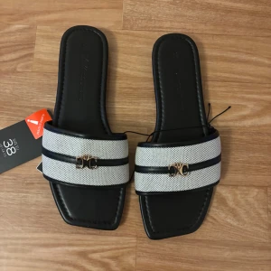 Svarta och vita sandaler med gulddetalj - Jag har använd tofflorna enstaka gånger 