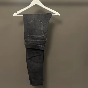 tiger of sweden jeansbyxor  Evolve 31/32 - Snygga svarta jeansbyxor från Evolve, tillverkade i Italien. Modellen har klassisk femficksdesign, raka ben och normal passform. Jeansen är i mörk tvätt och har metallknapp framtill. Perfekta för dig som gillar stilrena och tidlösa jeans.