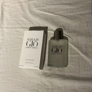 Acqua di Giò Eau de Toilette 100ml - Fräsch parfym från Giorgio Armani, Acqua di Giò, i en stilren frostad glasflaska med silverfärgad kork. Flaskan rymmer 100 ml och har en modern, minimalistisk design. Kommer med originalkartong.