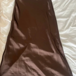 Satin kjol - Brun satin kjol från NAKD. Använd ett fåtal gånger. Väldigt bra skick!