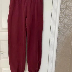 Vinröda mjukisbyxor med resår - Helt nya oanvända! Mysiga vinröda mjukisbyxor med resår i midjan och vid bensluten. Perfekta för chill dagar eller när du vill vara extra bekväm. Tillverkade i mjukt material som känns skönt mot huden. Köpta på Brandy Melville. Storleken passar small till large! 