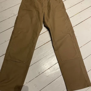 Levi's Workwear cargopants khaki - Säljer ett par khakifärgade cargopants från Levi's Workwear med raka ben och flera praktiska fickor. Byxorna har normal passform och är tillverkade i slitstark bomull. Perfekta för dig som gillar utility-stil och vill ha något som funkar till streetwear.