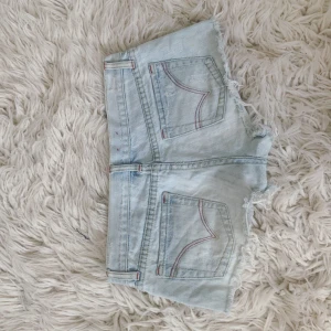 Lågmidjade ljusblåa jeanshorts med fransar - Världens snyggaste wow💞 musik rakt över: ca 39,5 cm💞 finns 3 fläckar se sista bild! (Dessa är på olika ställen men e verkligen inget som är speciellt märkbart vilket kan ses på alla andra bilder)