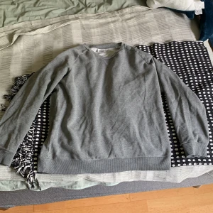 Grå sweatshirt från Weekday M - En stilren grå sweatshirt från Weekday i storlek medium. Tröjan har rund halsringning, ribbade muddar vid ärmslut och nederkant samt en klassisk passform. Perfekt för lager-på-lager och chill dagar.