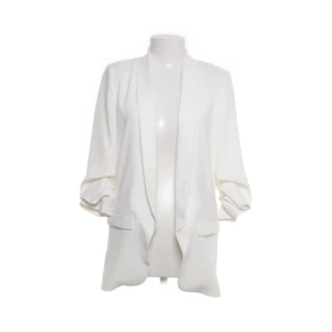 Vit kavaj från Zara med fickor - Snygg vit kavaj från Zara med avslappnad passform och långa ärmar. Kavajen har två fickor framtill och en öppen design utan knappar. Perfekt för en clean och stilren look. Materialet känns mjukt och lätt, vilket gör den enkel att bära. Stor i storleken och passar XS-M beroende på hur man vill att den ska sitta. 