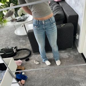 Ljusblå bootcut jeans från H&M💗 - Säljer ett par ljusblå bootcut jeans från H&M. Dem är low waist och inte använda mycket.  Jeansen har snygga fickdetaljer framtill med lock och dubbla knappar i midjan. Inga bakfickor och rimligt pris till💗