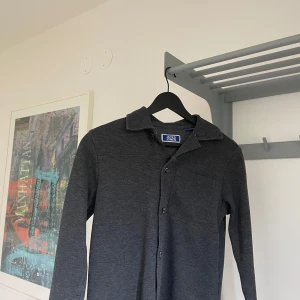 Jack & Jones Overshirt - En snygg mörkgrå overshirt från Jack and Jones. Den är storlek 140 men sitter mer som 152 ungefär. Kontakta om eventuella frågor.
