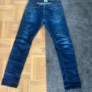 Mörkblå jeans från Edwin ED-75 - Säljer ett par mörkblå Edwin ED-75 jeans med klassisk femficksdesign och orangea sömmar. Modellen är mid rise tapered vilket ger en snygg passform som smalnar av nedtill. Perfekta för dig som gillar stilrena jeans med japansk kvalitet.