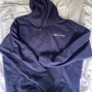 Mörkblå hoodie från Polo Ralph Lauren - Säljer en mörkblå stilren hoodie från Polo Ralph Lauren. Perfekt inför sommarkvällar och lite kyligare dagar. Skicket är 10/10 då jag fick den i present men inte använt speciellt mycket. Storleken är M men passar även S. Nypris ligger på 2200 men säljer den billigt eftersom jag bara vill få sålt den. 