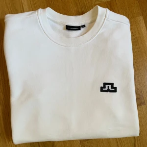 Vit sweatshirt från J.Lindeberg XS - Helt ny vit sweatshirt från J.Lindeberg i bomull. Klassisk rund halsringning och långa ärmar. Enkel och stilren design. Storlek XS