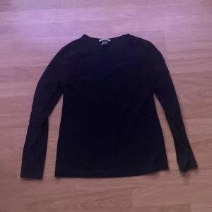 Svart långärmad tröja från H&M - En enkel svart långärmad tröja från H&M. Tröjan har rund halsringning och är tillverkad i ett mjukt material som passar perfekt till vardags. Klassisk och stilren modell som är lätt att matcha med olika outfits.