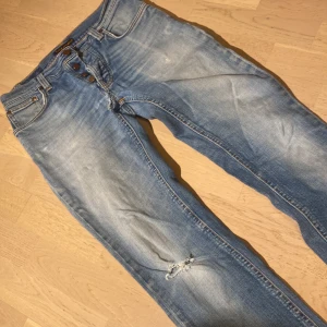 Nudie jeans - Snygga blåa nudies med en sliten design, dom har dock ett hål som man kan se på sista bilden fast det går att fixa gratis på nudie butiken. Modell grim Tim 