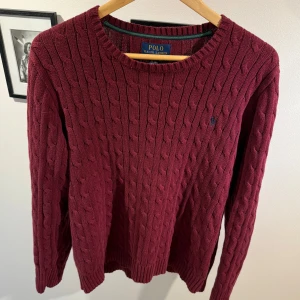 Ralph Lauren tröja - Vinröd kabelstickad tröja från Polo Ralph Lauren. Nypris ligger på 2000kr. Den har en utländsk storlek men sitter som L (köpt utomlands). Bara att skriva vid funderingar!😊